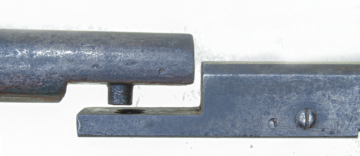 The integral pin on the barrel fits the hole in the breechblock, allowing it to resist firing pressure and pivot open for loading.